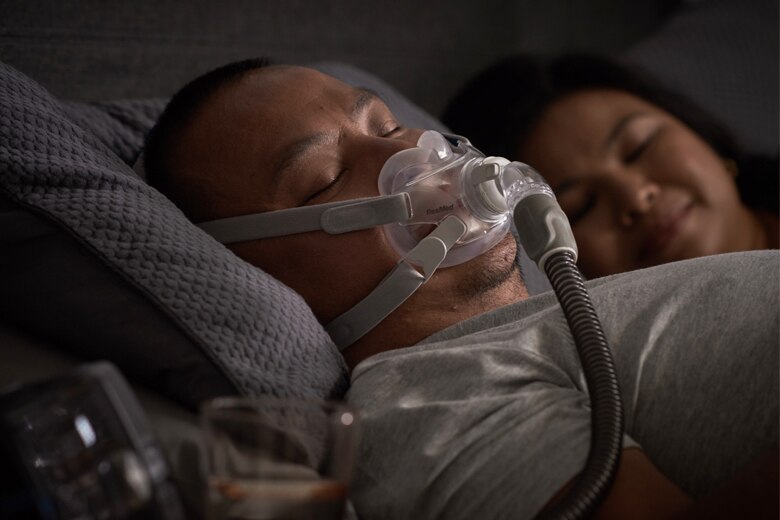 Man sleeps comfortably while wearing the AirFit F30 full face CPAP mask